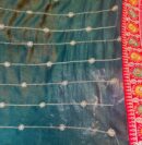Vibrant silk red saree with intricate floral borders include a dark green blouse piece , perfect for a festive look.